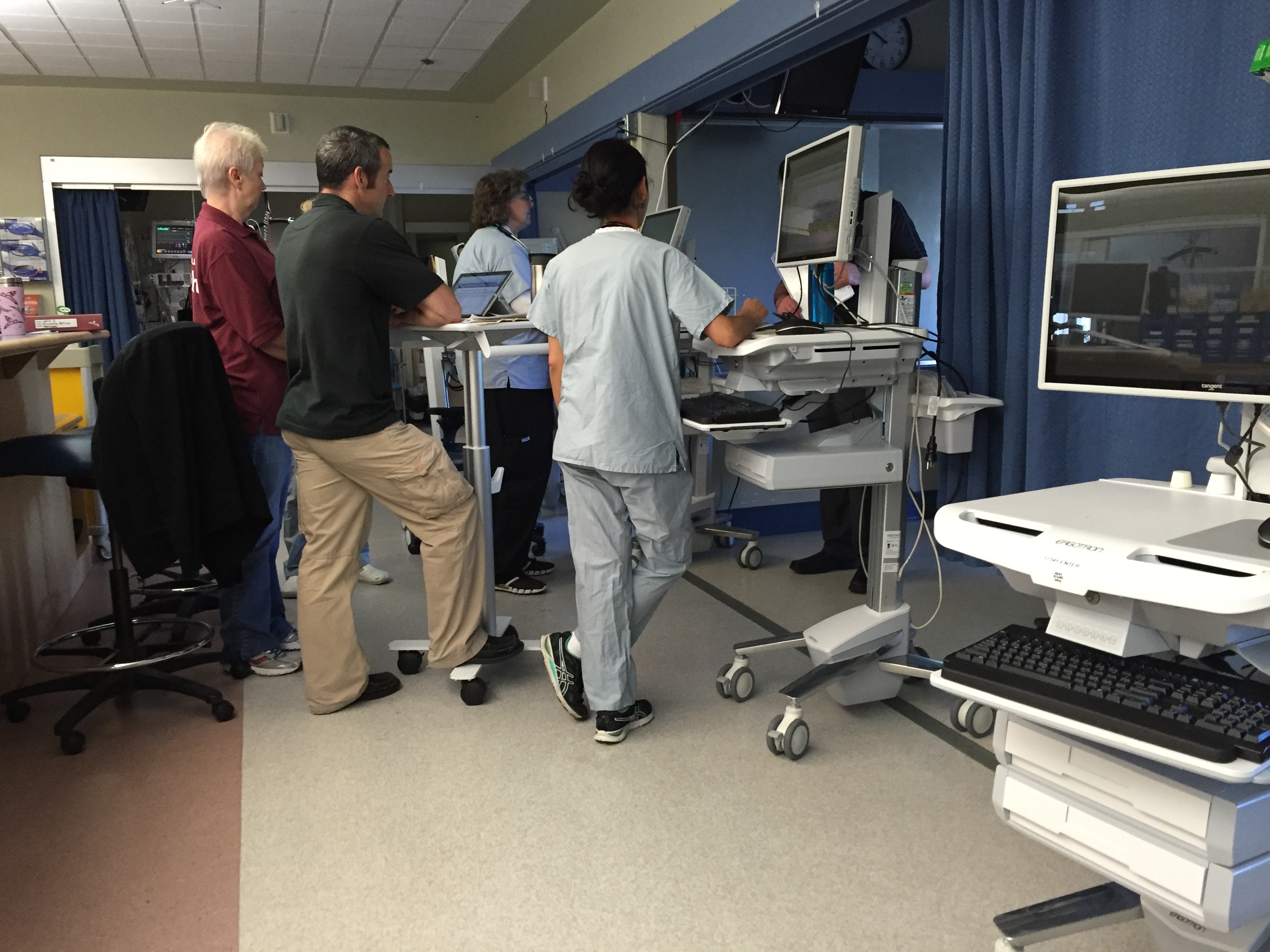 Clinicians working at mobile computer carts on the unit